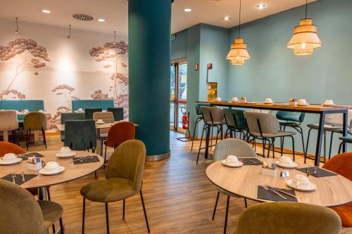 a restaurant with tables and chairs and a bar at Novotel Roma Est in Rome