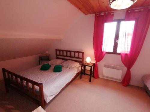 a bedroom with a bed and two windows at Gîte Monplaisir in Gère-Belesten