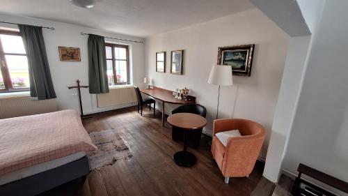 a bedroom with a bed and a desk and a table at Leipa Apart in Česká Lípa