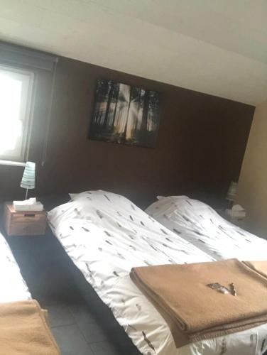 a bedroom with a white bed with a black headboard at « En toute simplicité chez Fabienne et Bruno » in Waimes