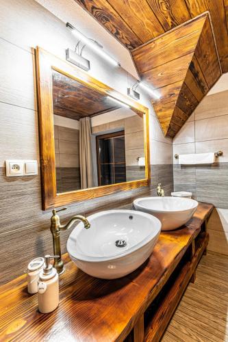 a bathroom with two sinks and a large mirror at Chalupa Katka in Dolný Kubín