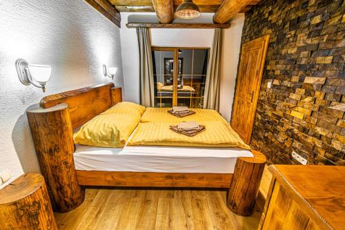 a bedroom with a wooden bed with a yellow blanket at Chalupa Katka in Dolný Kubín