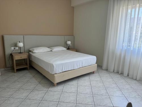 a bedroom with a white bed and a window at Niki's Apartment in Palaiochóra