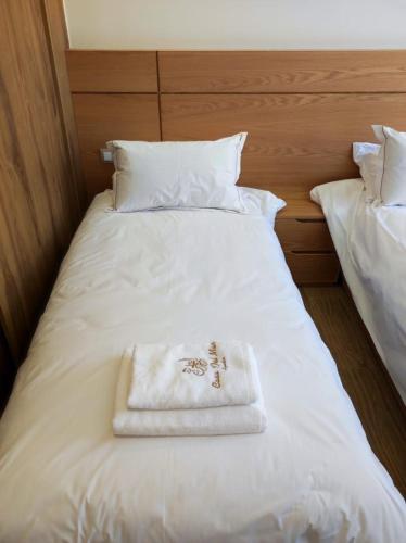 a white bed with a towel on top of it at Casa del mar in Agadir nʼ Aït Sa