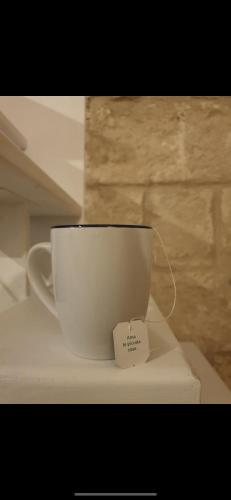 une tasse à café posée sur une étagère avec une étiquette dessus dans l'établissement Casa mia, à Latiano