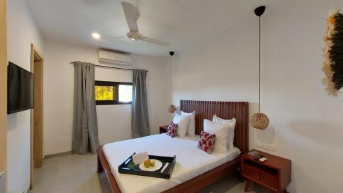a bedroom with a bed with a tray of food on it at L'Hédone, hôtel de charme in Ouagadougou