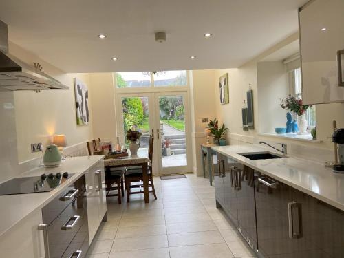 duża kuchnia z białymi blatami i dużym oknem w obiekcie Dolly's Cottage w mieście Warrenpoint