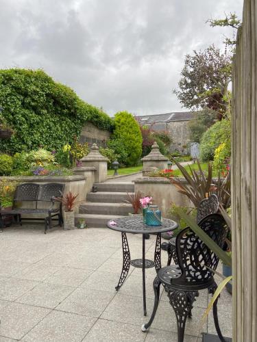 a patio with a table and chairs and stairs at Dolly's Cottage in Warrenpoint