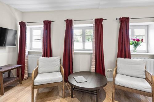 a living room with red curtains and a table and chairs at Lüdersburger Strasse 15a in Lüdersburg