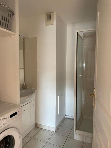 La salle de bains est pourvue d'un lave-linge et d'une douche. dans l'établissement T4 Chartrons Ravezies, à Bordeaux