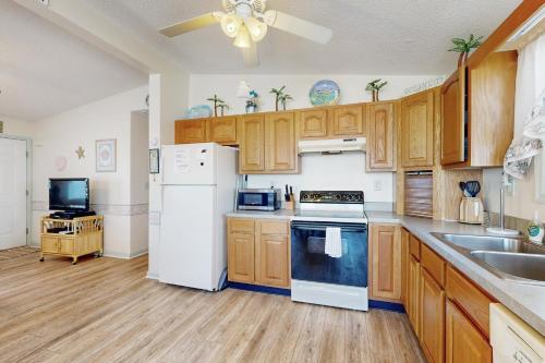 a kitchen with wooden cabinets and a white refrigerator at Pop Pop's Place in Ocean City