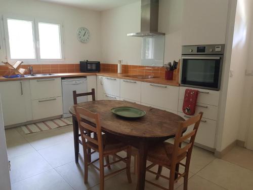 a kitchen with a wooden table with chairs and a television at Villa Linda in Margon