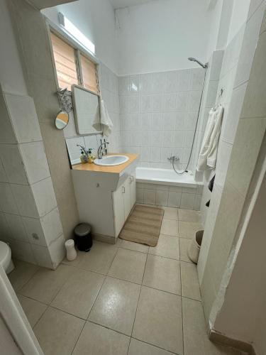 a bathroom with a sink and a tub and a toilet at 3 rooms apartment on the beach in Tel Aviv