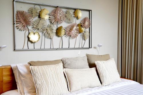 a picture hanging above a bed with pillows at Brand New! Private Room near Canggu Surfing Beaches in Canggu