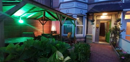 a house with a patio with a green lights at Morwenna Holiday Apartments in Llandudno