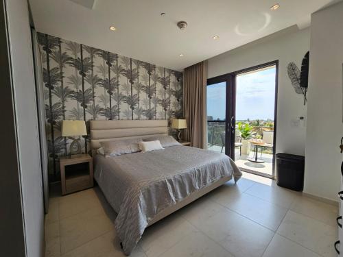 una camera da letto con un letto grande e una grande finestra di Wariruri Condo Aruba a Palm Beach