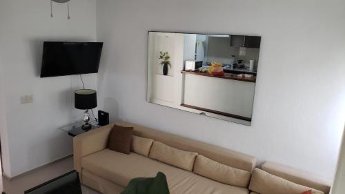 a living room with a couch and a mirror at Departamento equipado a unos pasos de la playa, 2 Recamaras Aire acondicionado in Manzanillo