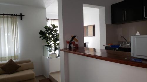 a kitchen and a living room with a counter top at Departamento equipado a unos pasos de la playa, 2 Recamaras Aire acondicionado in Manzanillo