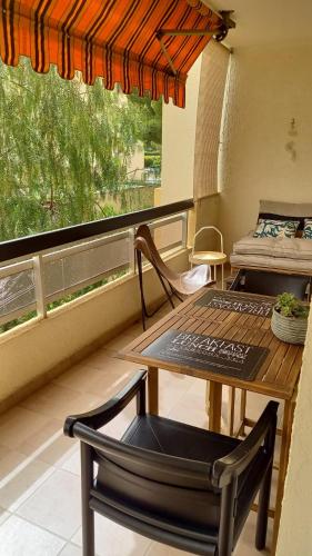 - un balcon avec une table, une chaise et un lit dans l'établissement Les Lavandes, à Sanary-sur-Mer