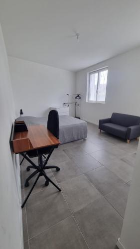 - une chambre avec un bureau et un lit dans l'établissement T2 37m2 proche Ker Lann Parc expo Aéroport, à Lassy