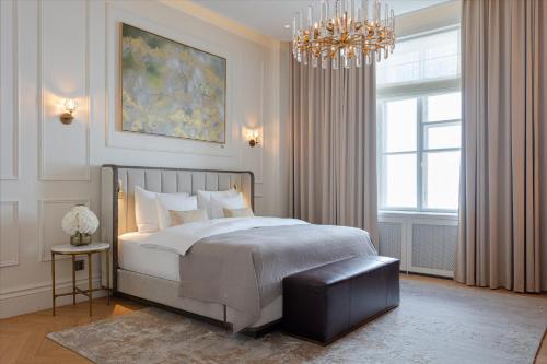 a bedroom with a large bed and a chandelier at The Hotel Maria Helsinki in Helsinki