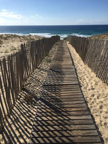une clôture en bois sur la plage à côté de l'océan dans l'établissement LouEva, à Mimizan