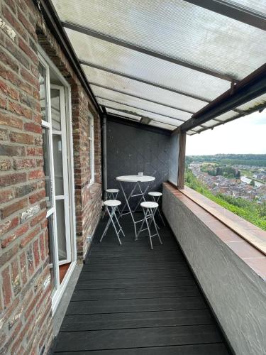 a balcony with a table and chairs on it at Au beffroi in Thuin