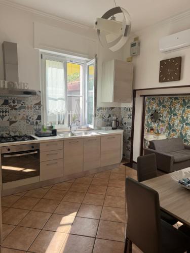 kuchnia z białymi szafkami, stołem i zlewem w obiekcie Gioviale House Pescara w mieście Pescara