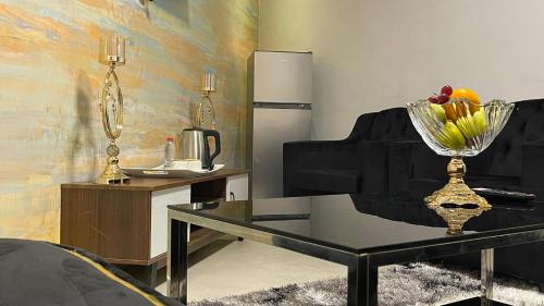 a living room with a table and a refrigerator at Hôtel Vendôme Douala in Douala