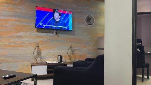 a room with a television on a wall at Hôtel Vendôme Douala in Douala