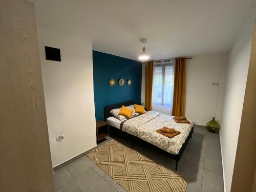 une chambre avec un lit et un mur bleu dans l'établissement Appartement coeur du village, à Villes-sur-Auzon
