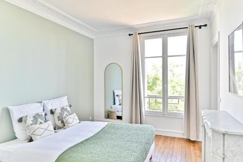 une chambre blanche avec un lit et un miroir dans l'établissement Magnifique et spacieux appartement proche Paris, à Puteaux