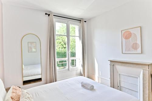 une chambre avec un lit et un miroir dans l'établissement Appartement lumineux Banlieue Parisienne - Puteaux, à Puteaux