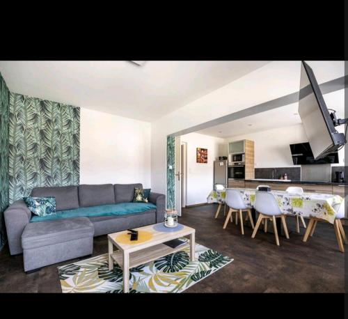 a living room with a couch and a table at GM GÎTE maison neuve et tout confort in Lucey