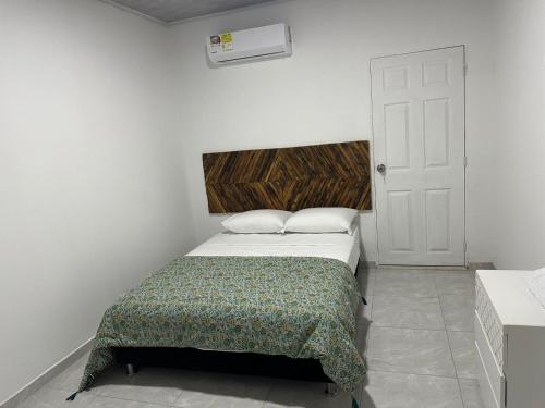 a small bedroom with a bed and a white door at Hostal mayapo confort in Mayapo