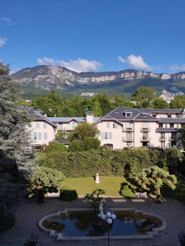 un grand bâtiment avec un jardin en face dans l'établissement Le Splendide Cosy Room, à Aix-les-Bains