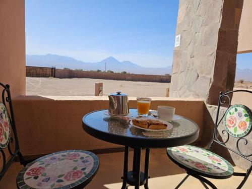 a table with food and drinks on a balcony at Hotel Pirwa in San Pedro de Atacama