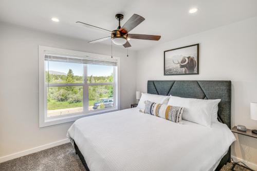 una camera da letto con un letto con un ventilatore a soffitto e una finestra di Private Hot Tub Newly Built Fraser Townhome a Fraser