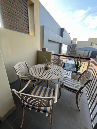 a patio with a table and chairs on a balcony at Low Tide in Densainagar