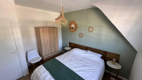 une chambre avec un lit et un mur végétal dans l'établissement Maison de Tara à la mer, à Étaples