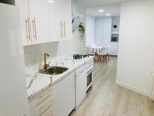 a white kitchen with a sink and a stove at Deluxe Familiar - Apartamentos Birdie in Albacete