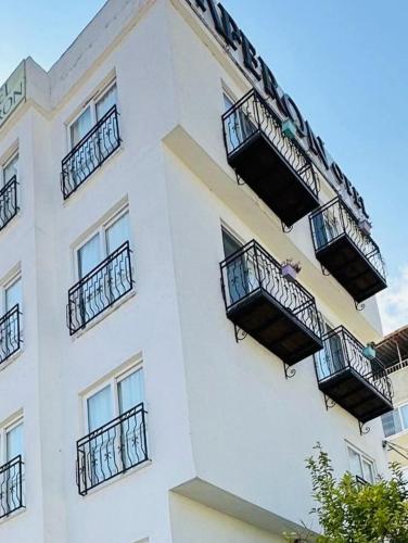 a white building with balconies on the side of it at Paperon Butik Otel in Limonlu