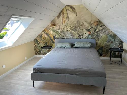 une chambre avec un lit avec un tableau sur le mur dans l'établissement Ty Mein, à Lampaul