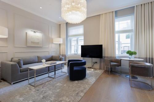 a living room with a couch and a tv at The Hotel Maria Helsinki in Helsinki
