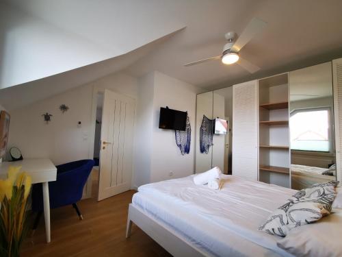 a bedroom with a large white bed and a desk at Aravell E23 Darłówko Wschodnie in Darlowko