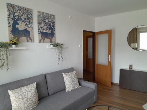 ein Wohnzimmer mit einem grauen Sofa und einer Tür in der Unterkunft Apartment in the heart of Myjava Town in Myjava
