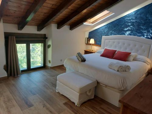 a bedroom with a large white bed with red pillows at Apartamentos Iparagirre in Ispáster