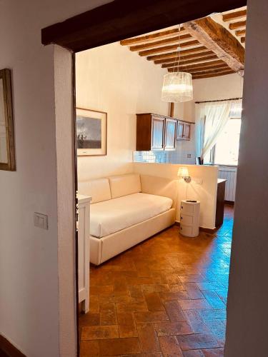 a living room with a white couch and a kitchen at Tenuta di Montemassi Fattoria in Montemassi