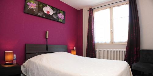 um quarto com uma cama branca e uma parede roxa em Logis Le Franco Belge em Monthermé