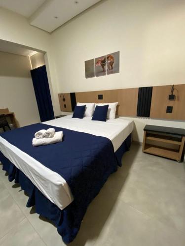 a bedroom with a large bed with towels on it at Visionsul Hotel in Chapadão do Sul